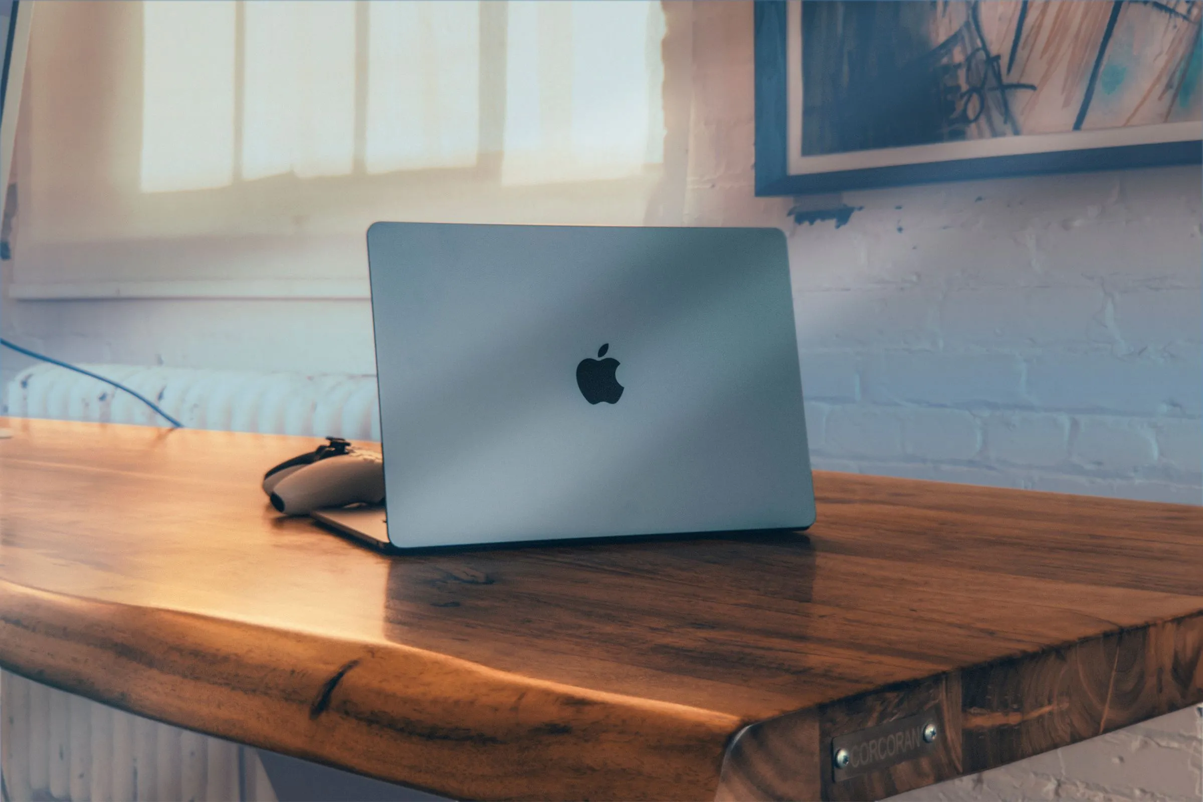 Chiếc MacBook Air hiện đại đặt trên bàn gỗ, biểu tượng cho sự đơn giản và hiệu quả của hệ điều hành macOS.