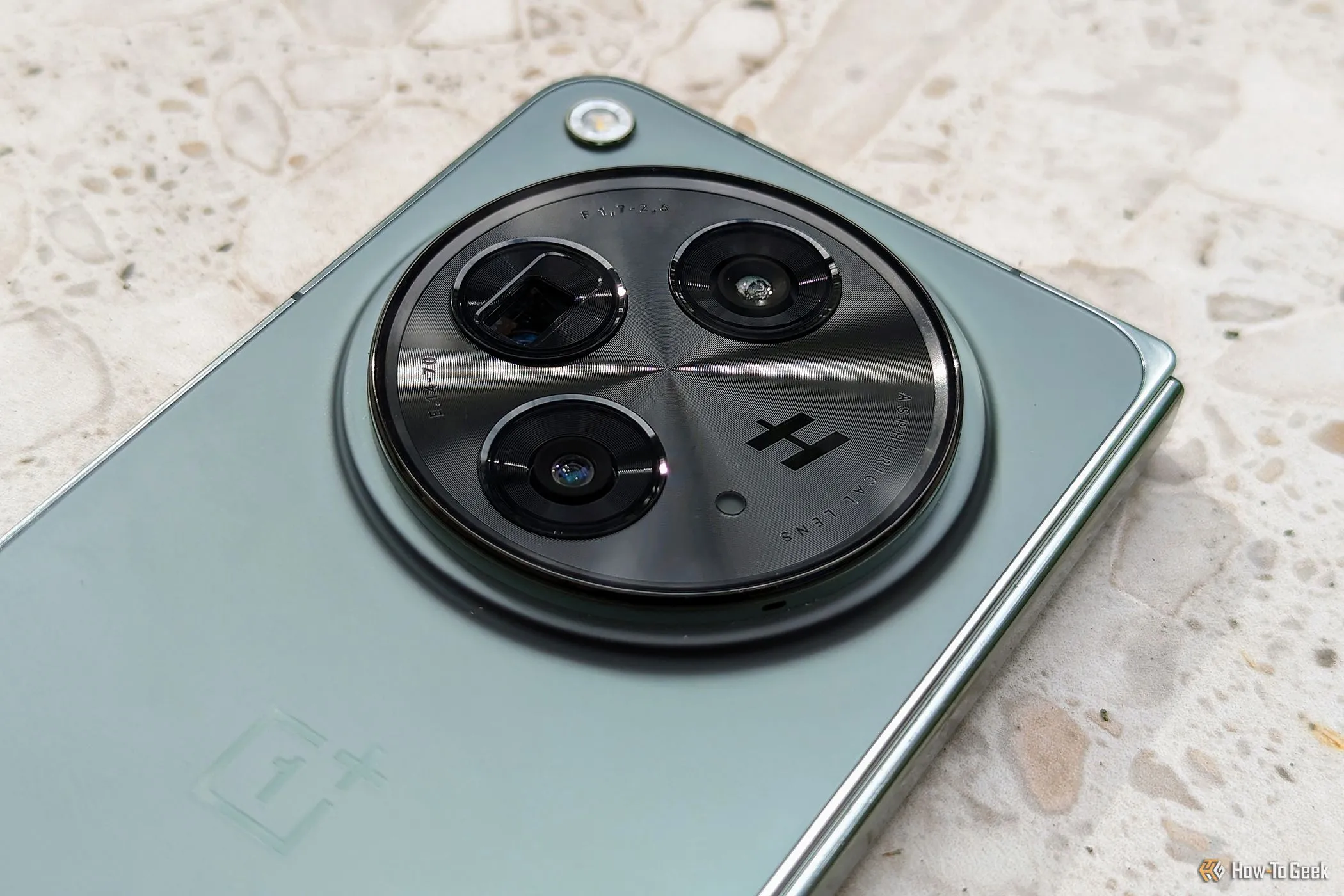 Cụm camera Hasselblad lớn trên mặt lưng của OnePlus Open, với ba ống kính và đèn flash, cho thấy khả năng chụp ảnh chuyên nghiệp và độ phân giải cao của smartphone này.