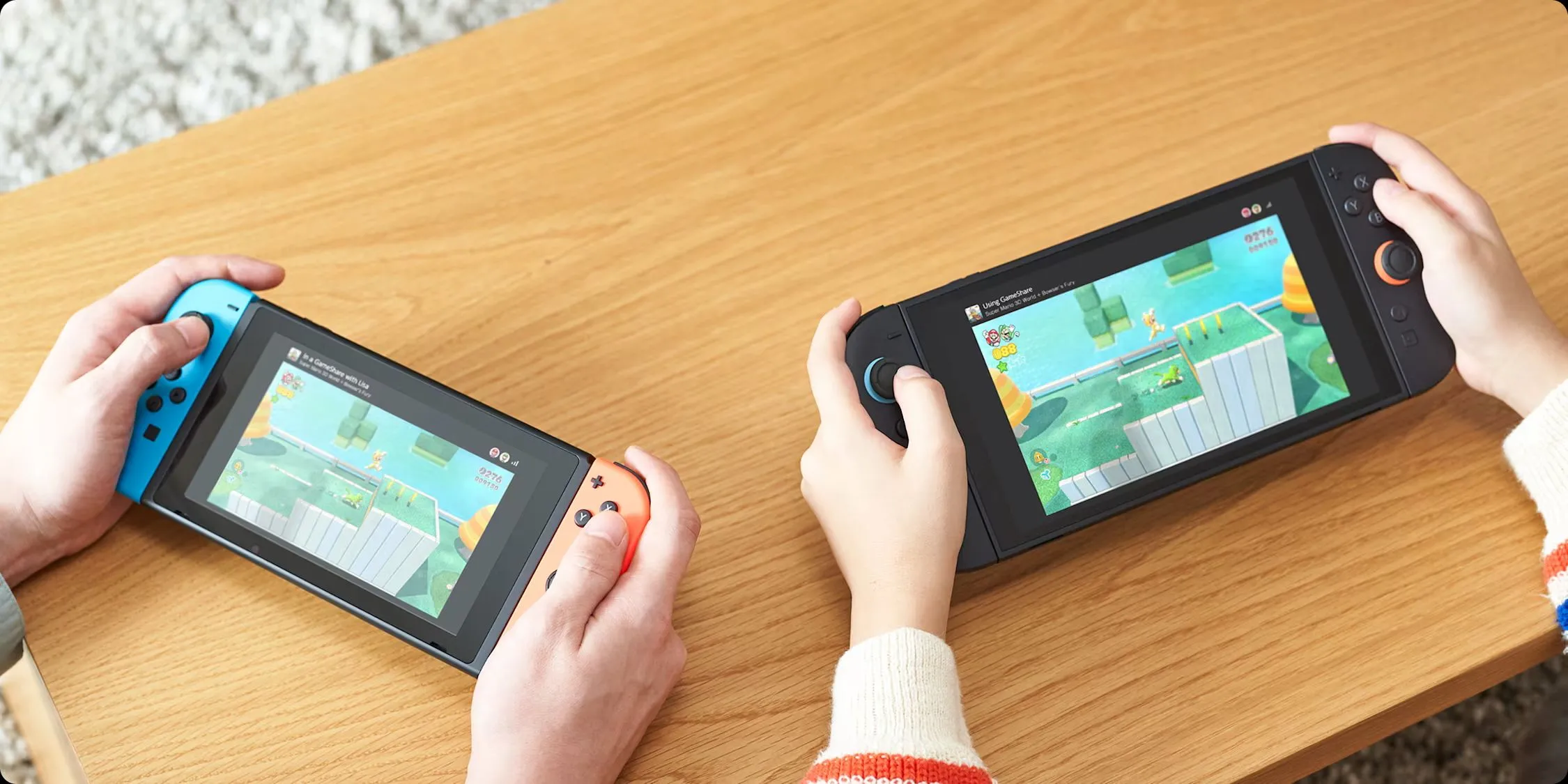 Hai máy chơi game Nintendo Switch, một Switch 2 và một Switch đời đầu, đang kết nối để sử dụng tính năng GameShare