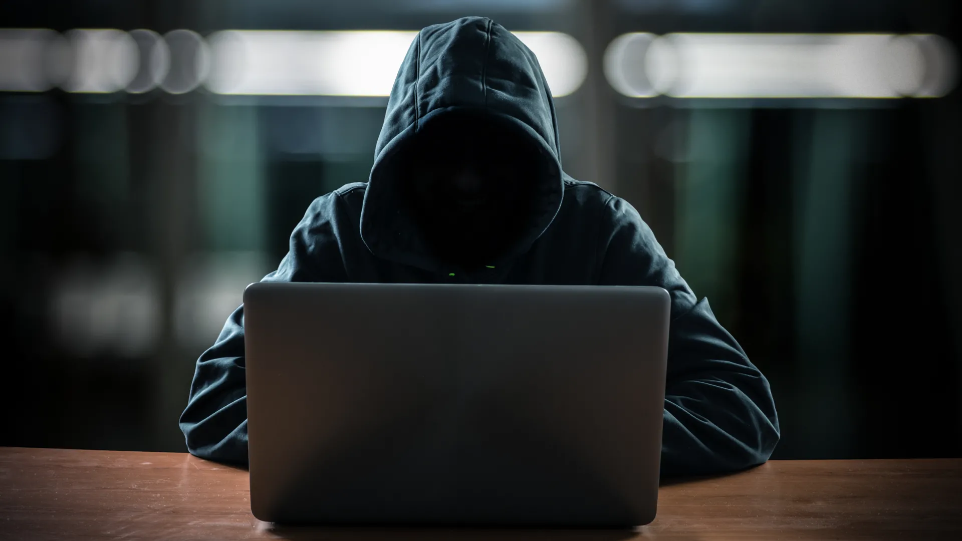 Hình ảnh hacker ẩn mình trước máy tính, thể hiện mối đe dọa bảo mật từ các hình thức tấn công như juice jacking.