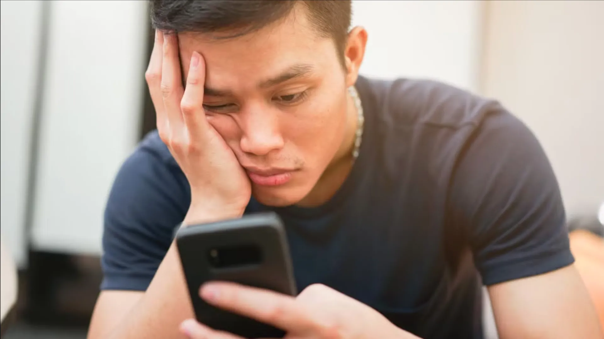 Hình ảnh một người đang lướt điện thoại với vẻ mặt mệt mỏi, phản ánh tình trạng doomscrolling.