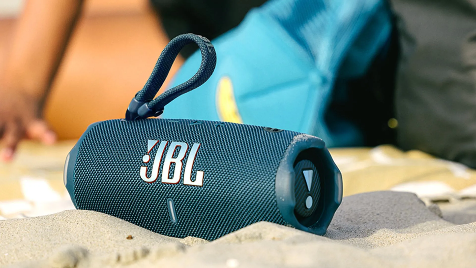 Loa Bluetooth JBL Charge 6 màu đen đặt trên cát, sẵn sàng cho các hoạt động ngoài trời