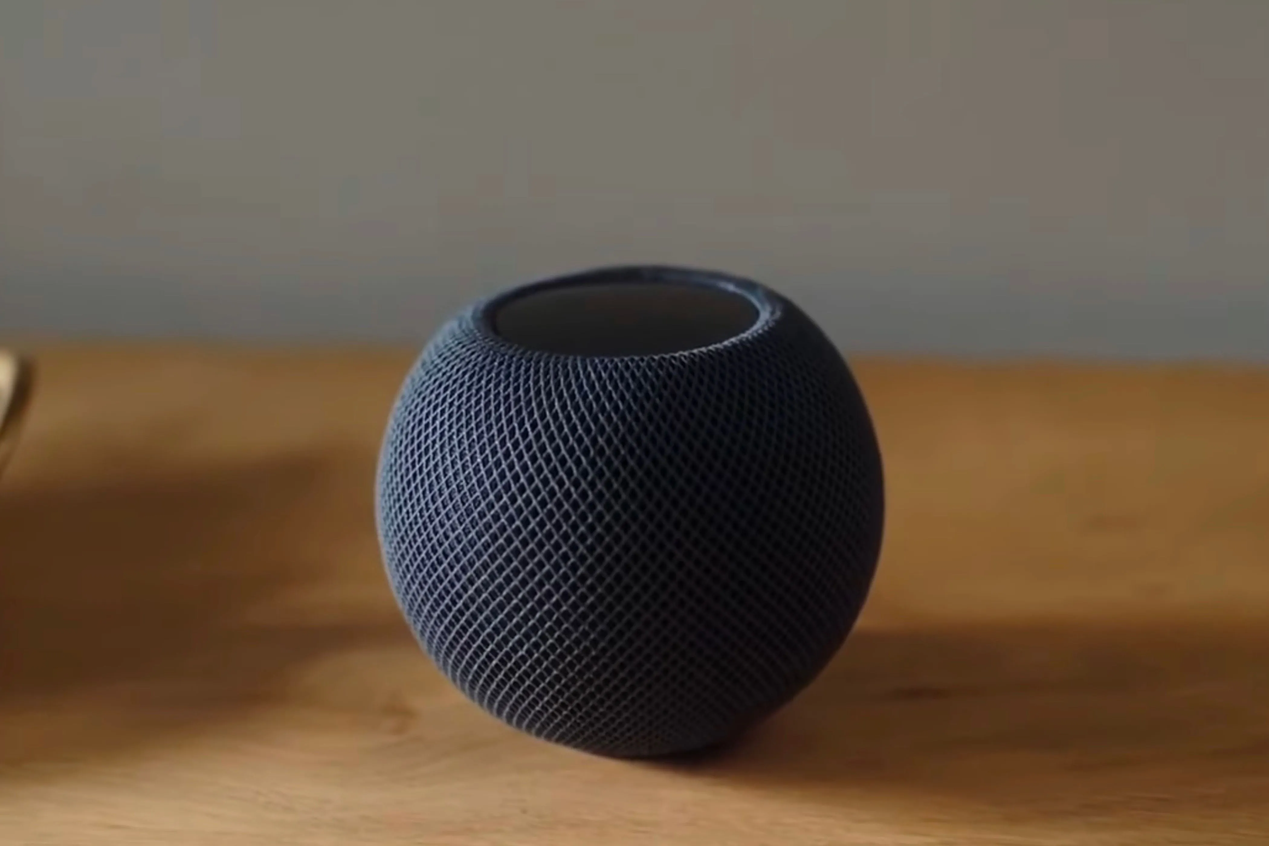 Loa thông minh HomePod Mini màu đen trên bàn gỗ, gợi ý về việc kiểm tra khả năng tương thích hệ sinh thái công nghệ