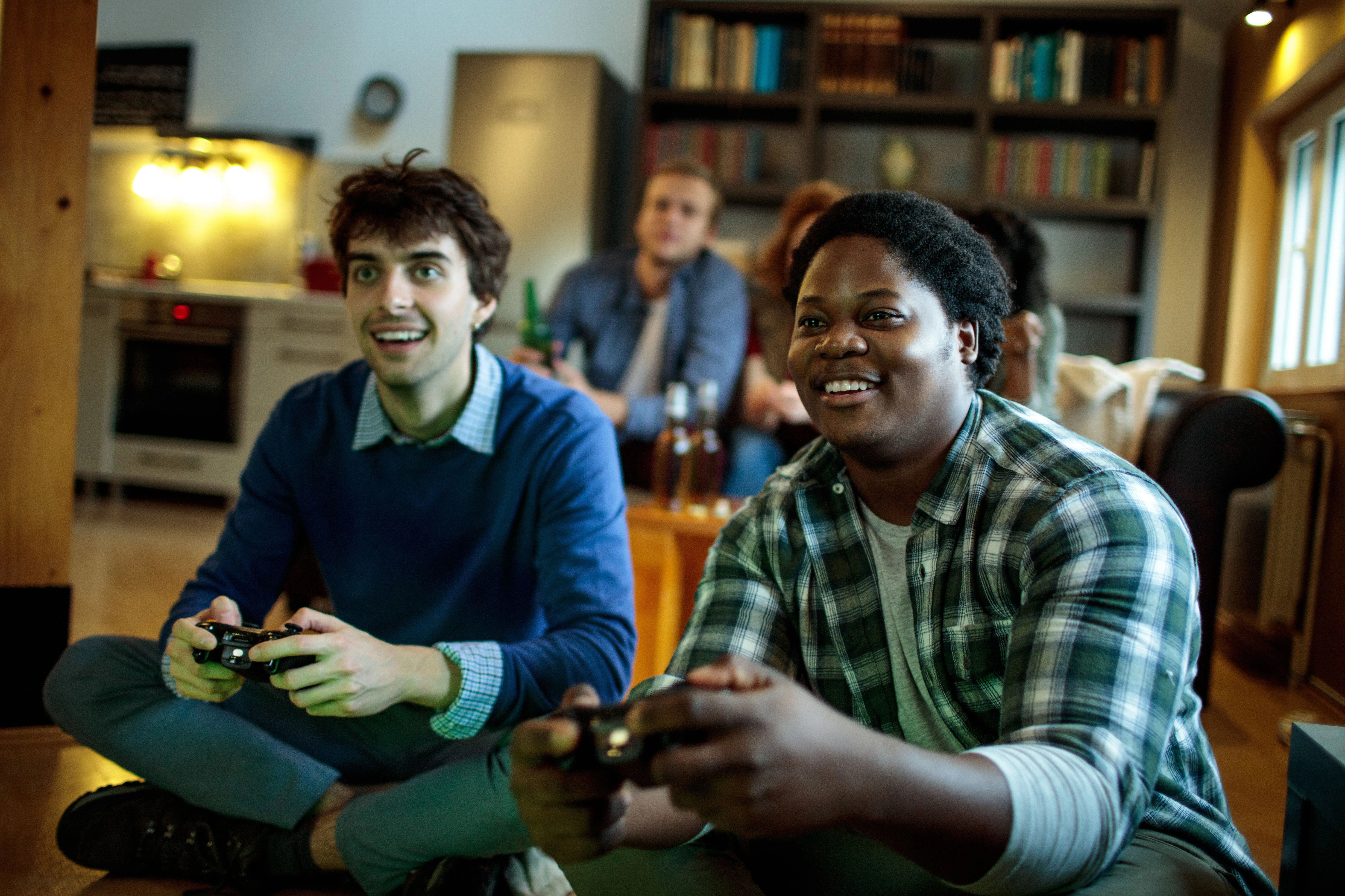 Nhóm người trẻ đang chơi game nhiều người chơi tại chỗ (couch co-op) trên PS5, thể hiện khả năng ứng dụng của Assist Controller.