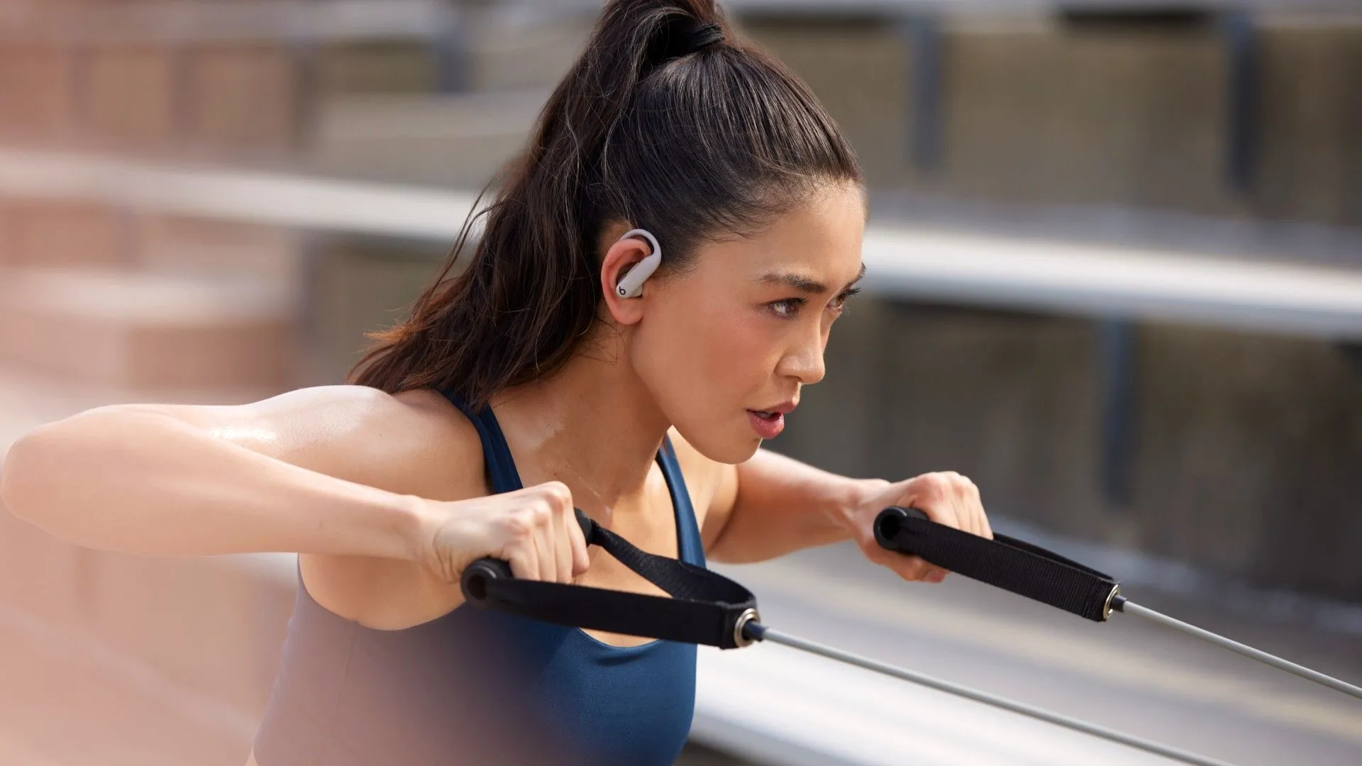 Tai nghe Powerbeats Pro 2 màu đen trên tai người phụ nữ đang tập thể dục