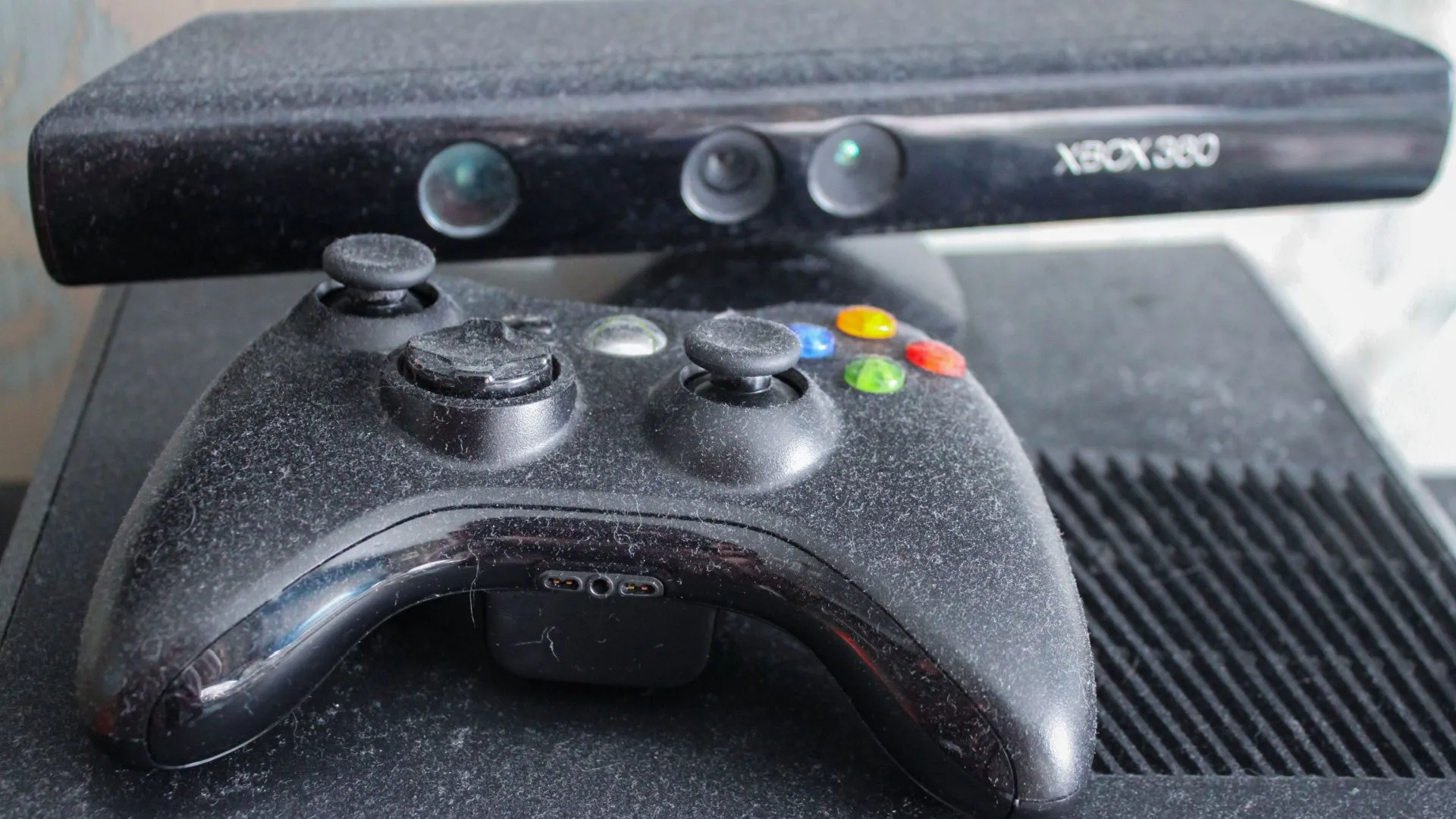 Tay cầm Xbox 360 cũ bám bụi và camera Kinect