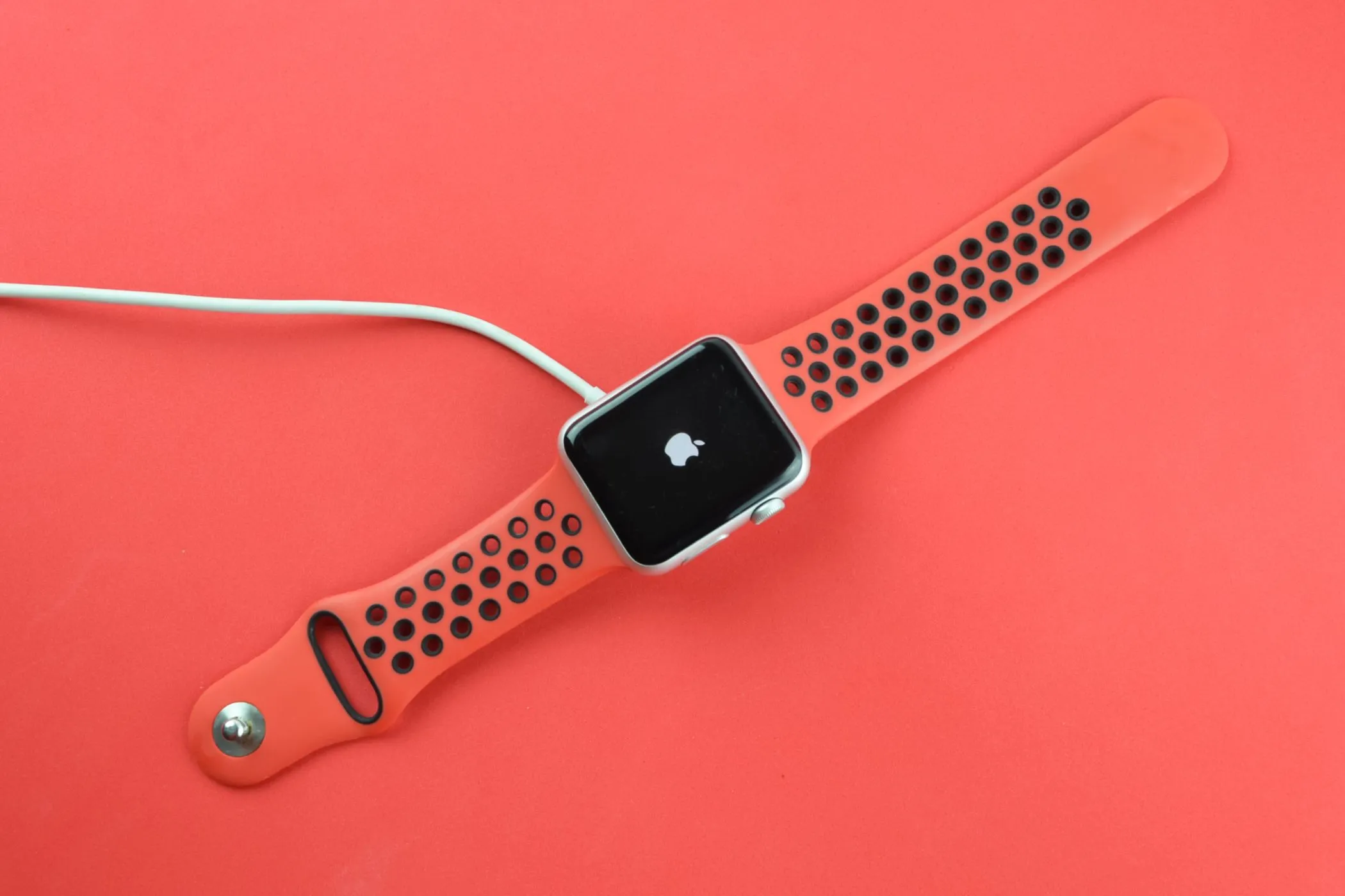 Apple Watch đang sạc, hiển thị logo Apple, biểu tượng của sự kết nối liên tục mà tác giả đang muốn tạm ngắt.