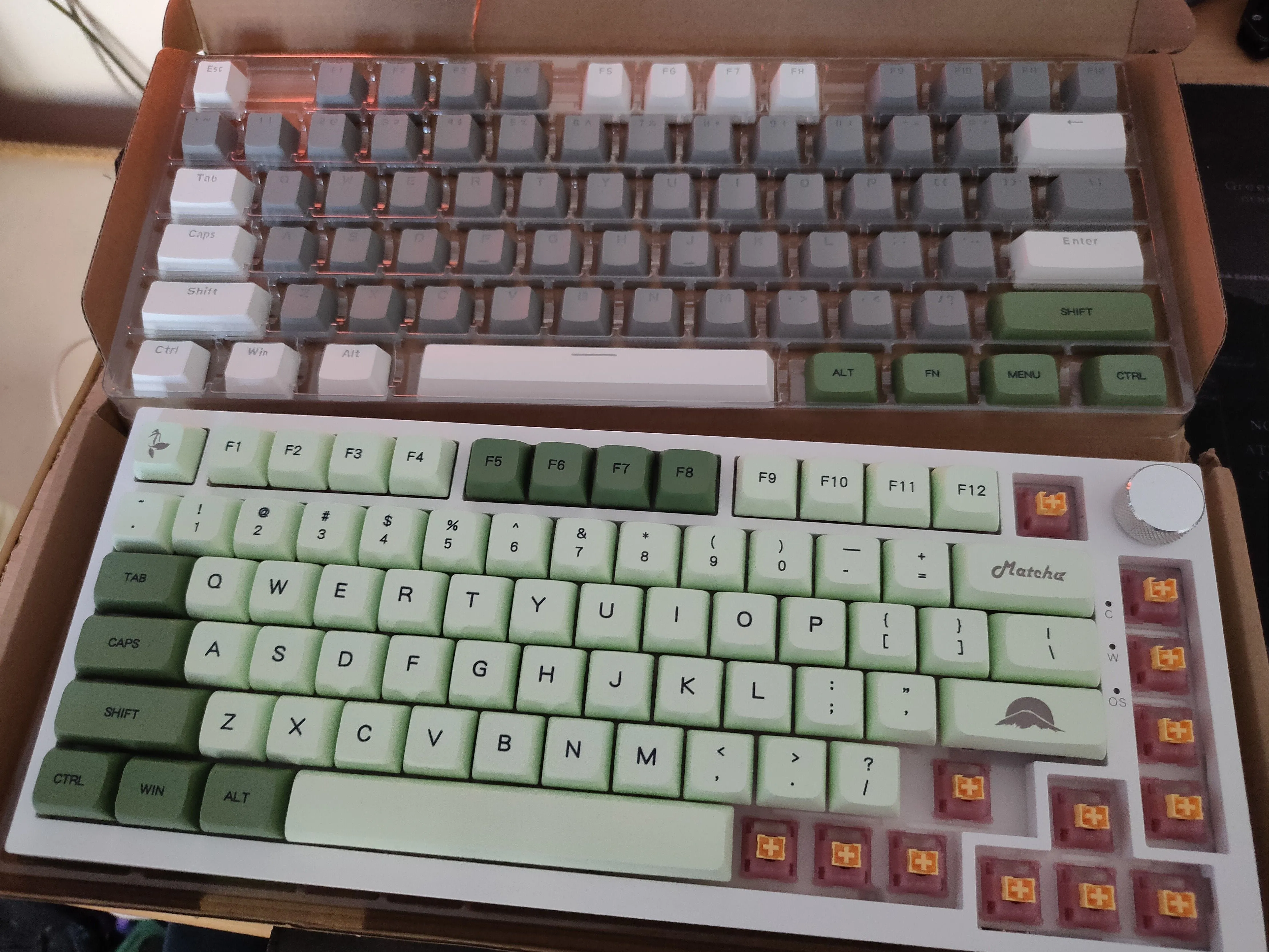 Bàn phím Ajazz AK820 đang được lắp đặt keycap màu xanh lá tùy chỉnh, bên trên là bộ keycap gốc