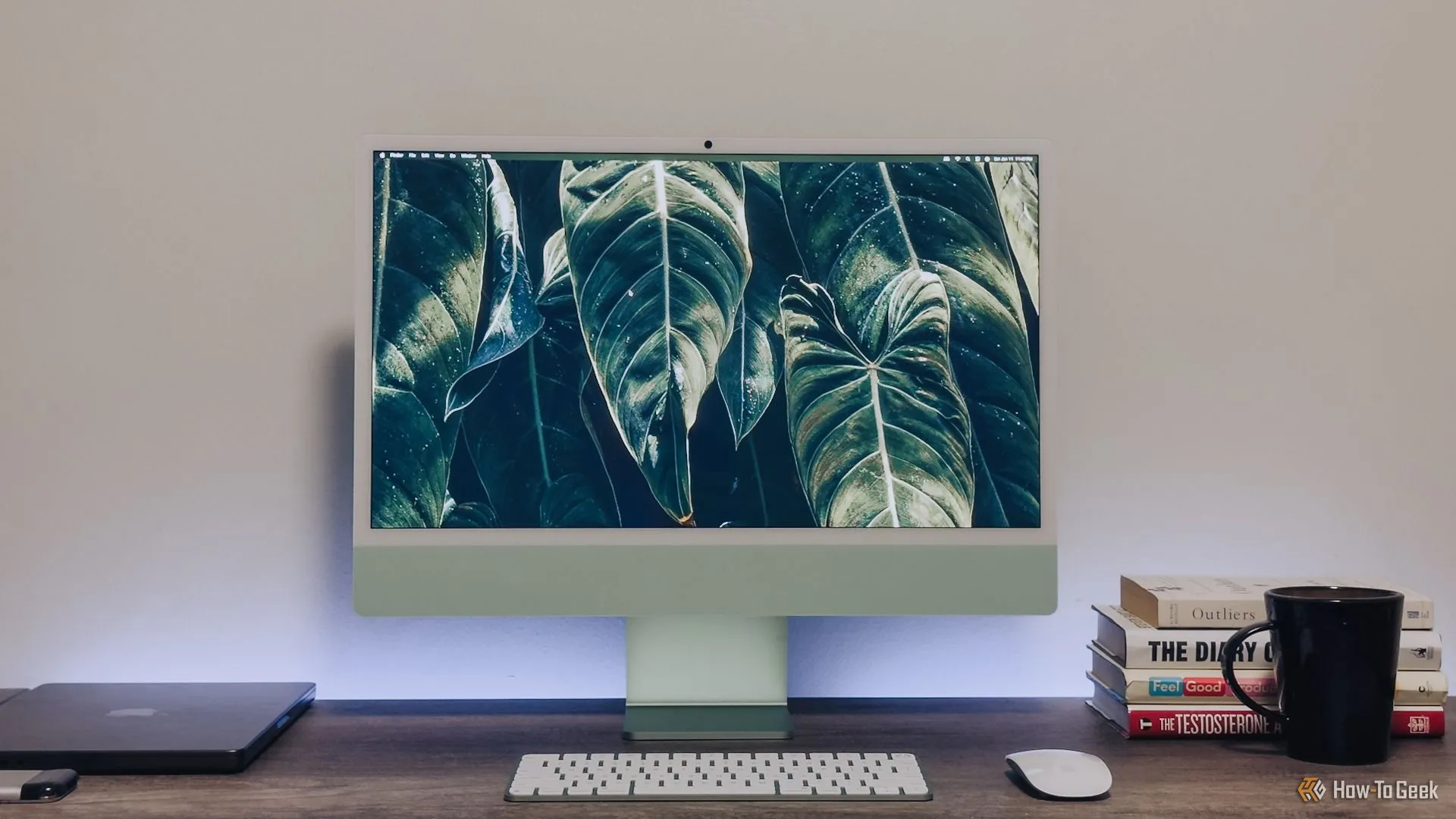 Bộ máy tính iMac M4 24 inch màu xanh lá đặt gọn gàng trên bàn làm việc, thể hiện thiết kế mới.