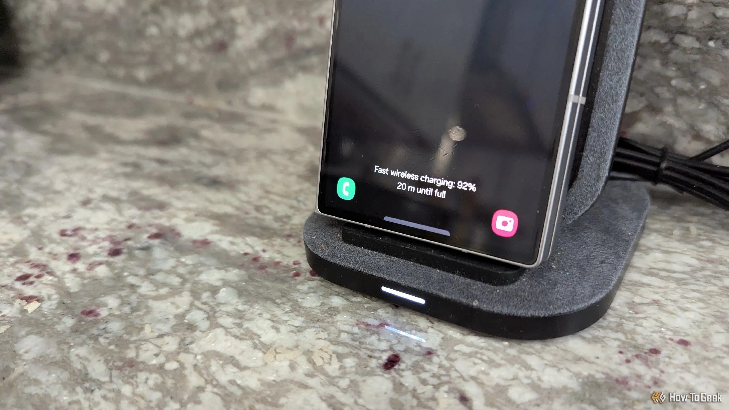 Điện thoại gập Samsung Galaxy Z Fold 6 đặt trên đế sạc không dây đứng trong bếp.