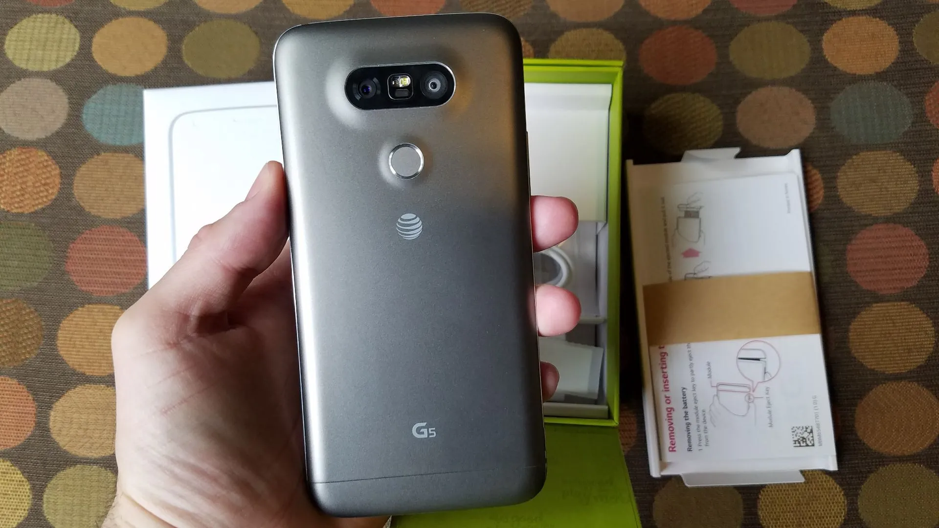 Điện thoại LG G5 màu xám bạc đang được cầm trên tay, làm nổi bật thiết kế mô-đun độc đáo ở cạnh dưới