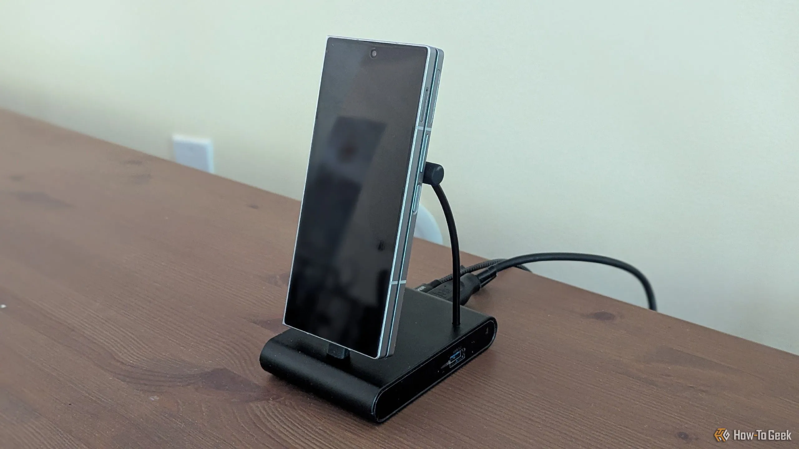 Điện thoại Samsung Galaxy Z Fold 6 đặt trên dock chuyển đổi, một phụ kiện quan trọng giúp kết nối smartphone với màn hình ngoài như TV hoặc máy tính.