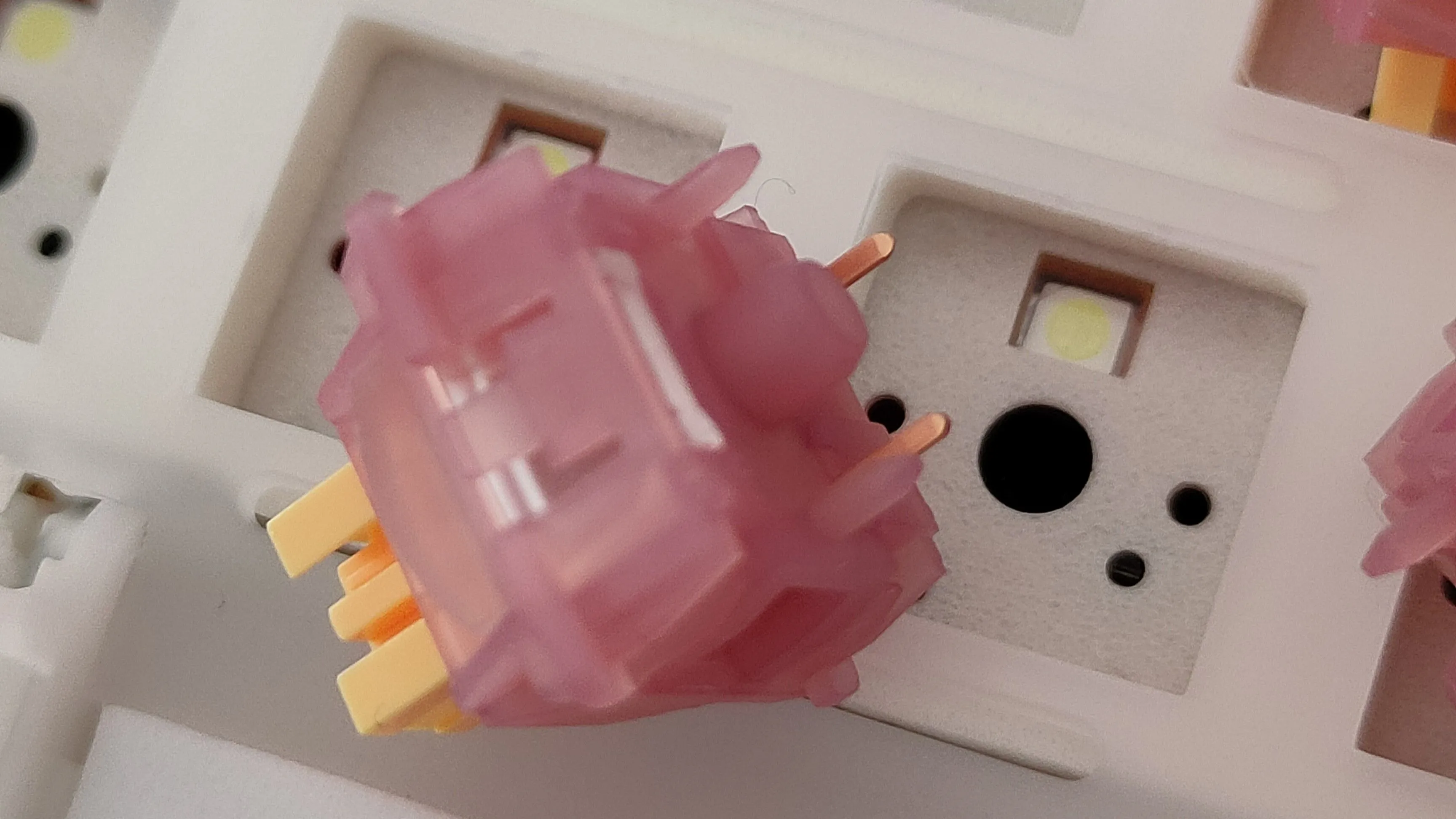 Hình ảnh cận cảnh một switch Outemu Silent Peach V3 với thiết kế màu hồng đào