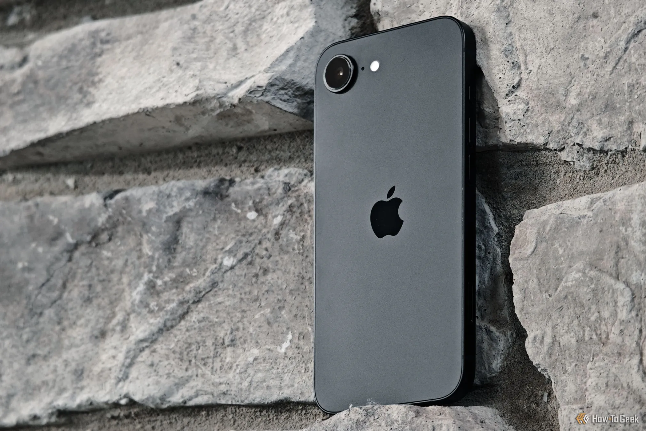 iPhone 16e tựa vào tường gạch, thiết bị tiên phong sử dụng modem C1 tự phát triển của Apple