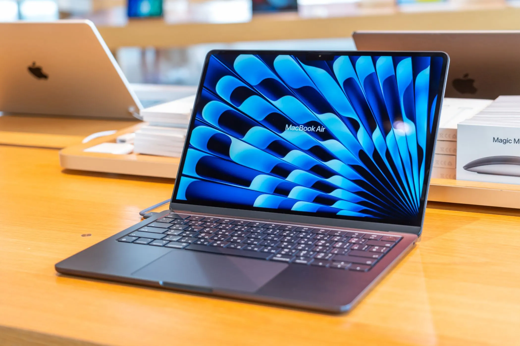 MacBook Air màu tối trưng bày trong cửa hàng Apple, đại diện cho dòng máy Mac hiện tại với RAM tối thiểu 16GB được tối ưu cho hiệu năng AI.
