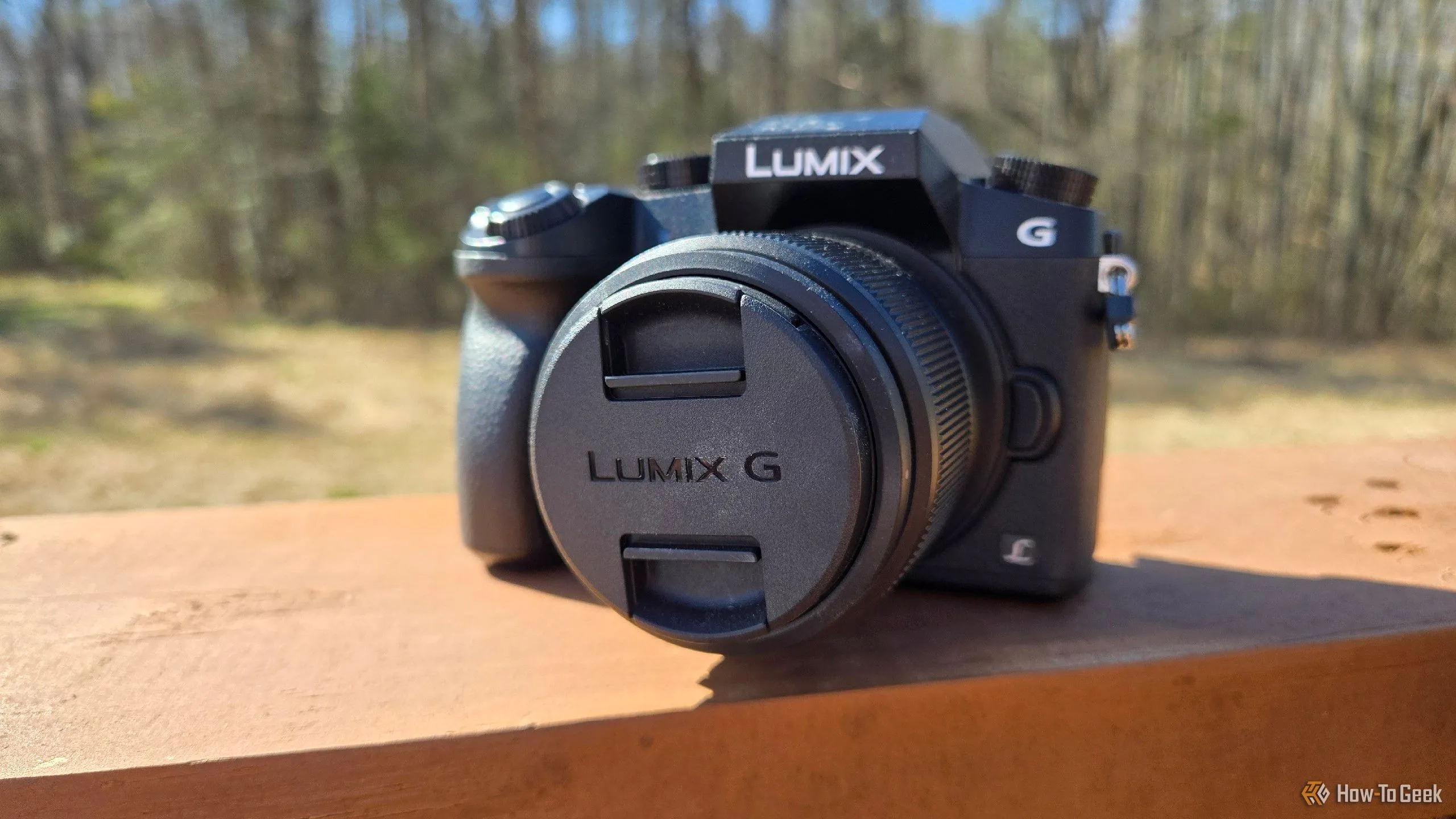 Máy ảnh mirrorless Panasonic Lumix G7 đặt trên lan can, đối lập với camera smartphone về chất lượng và tiện ích.