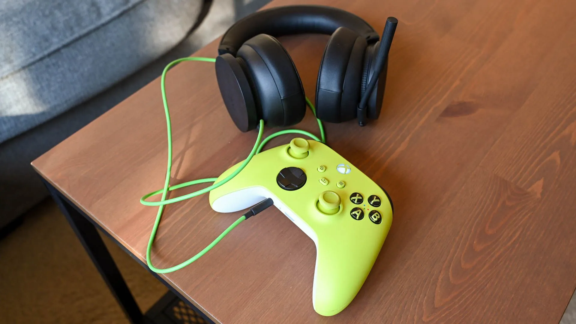 Một chiếc tay cầm Xbox Series X và tai nghe gaming được đặt trên bàn, thể hiện sự cần thiết của phụ kiện âm thanh.