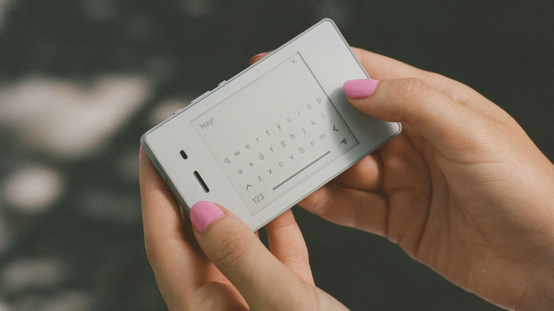Một người đang cầm chiếc Light Phone 2 với màn hình E-Ink đen trắng.