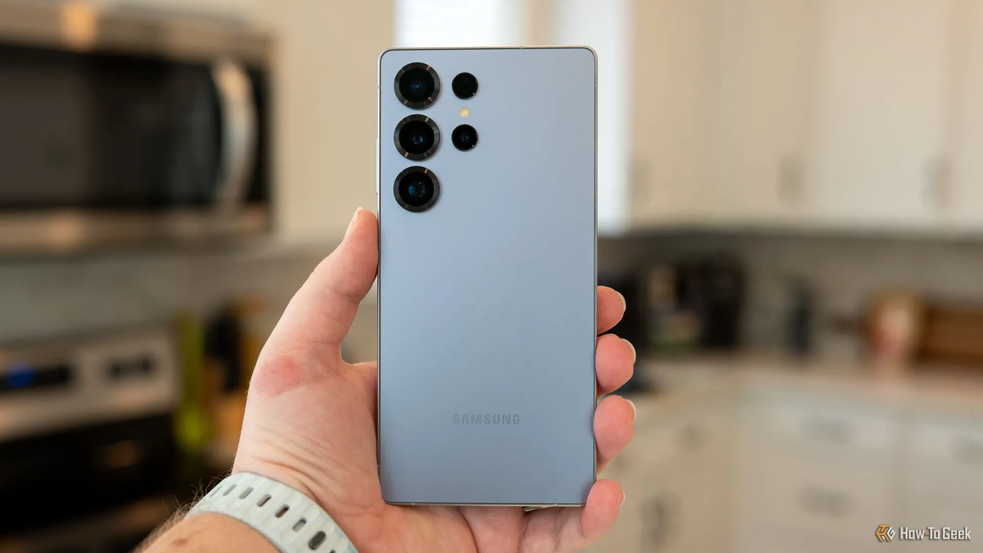 Một người đang cầm Samsung Galaxy S25 Ultra, khoe thiết kế mặt lưng và cụm camera đẳng cấp, nhấn mạnh vẻ ngoài cao cấp và camera chuyên nghiệp.