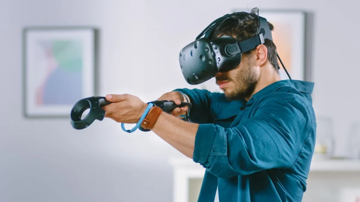 Người đàn ông trải nghiệm thực tế ảo (VR) với kính headset và bộ điều khiển, minh họa công nghệ game là nền tảng của VR/AR.