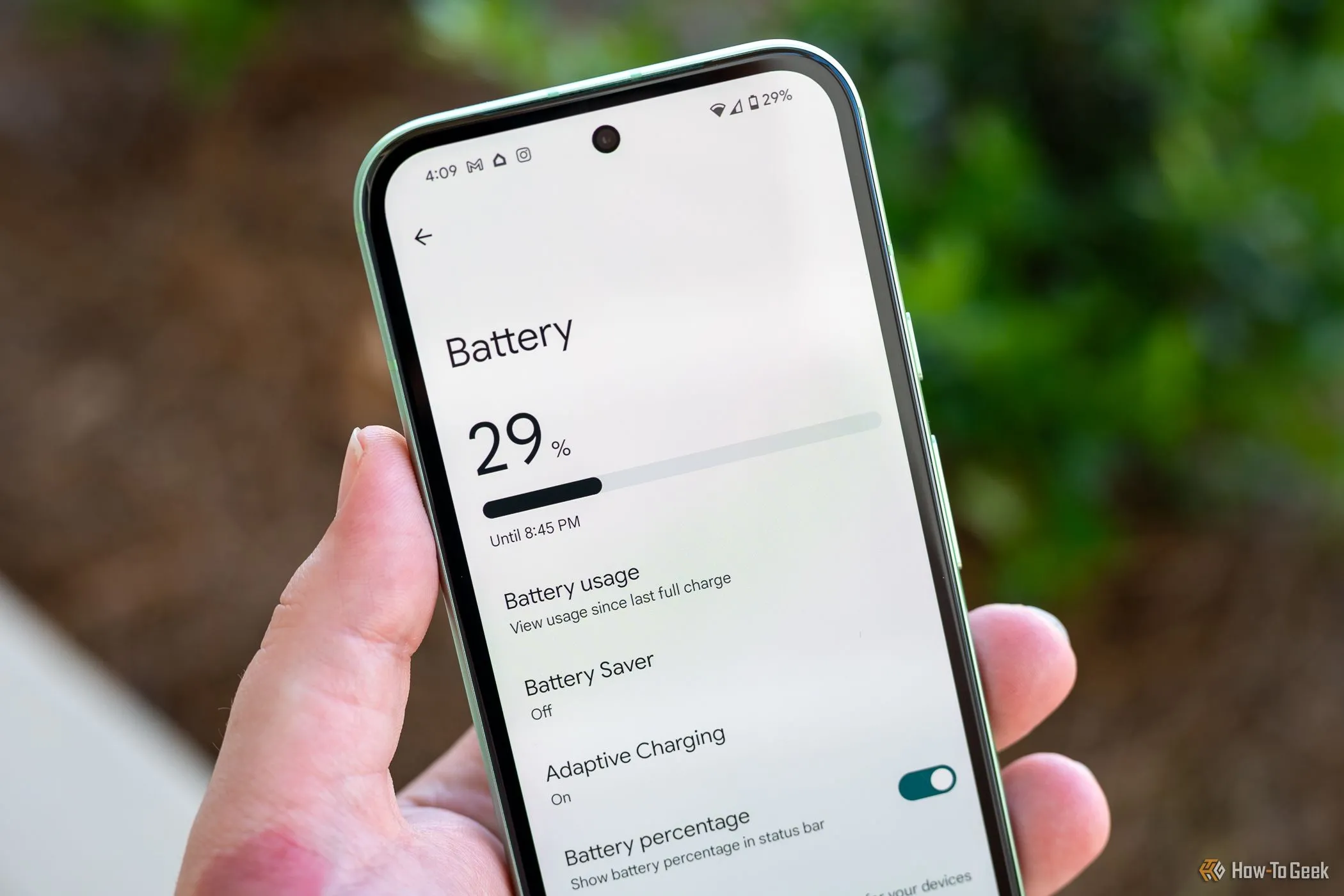 Người dùng cầm Google Pixel 8a hiển thị menu cài đặt pin, minh họa khả năng quản lý năng lượng và thời lượng pin của thiết bị.