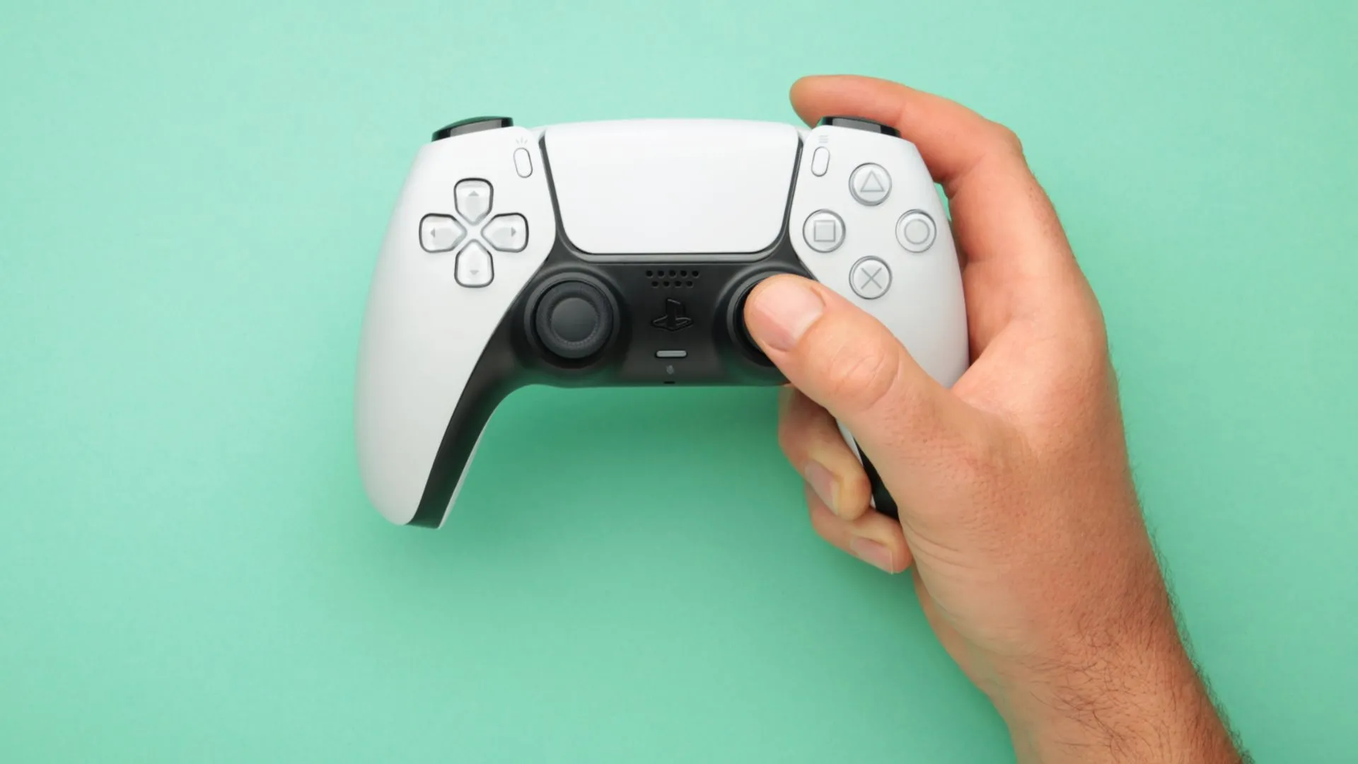 Người dùng cầm tay cầm DualSense của PlayStation với nút tắt tiếng micro