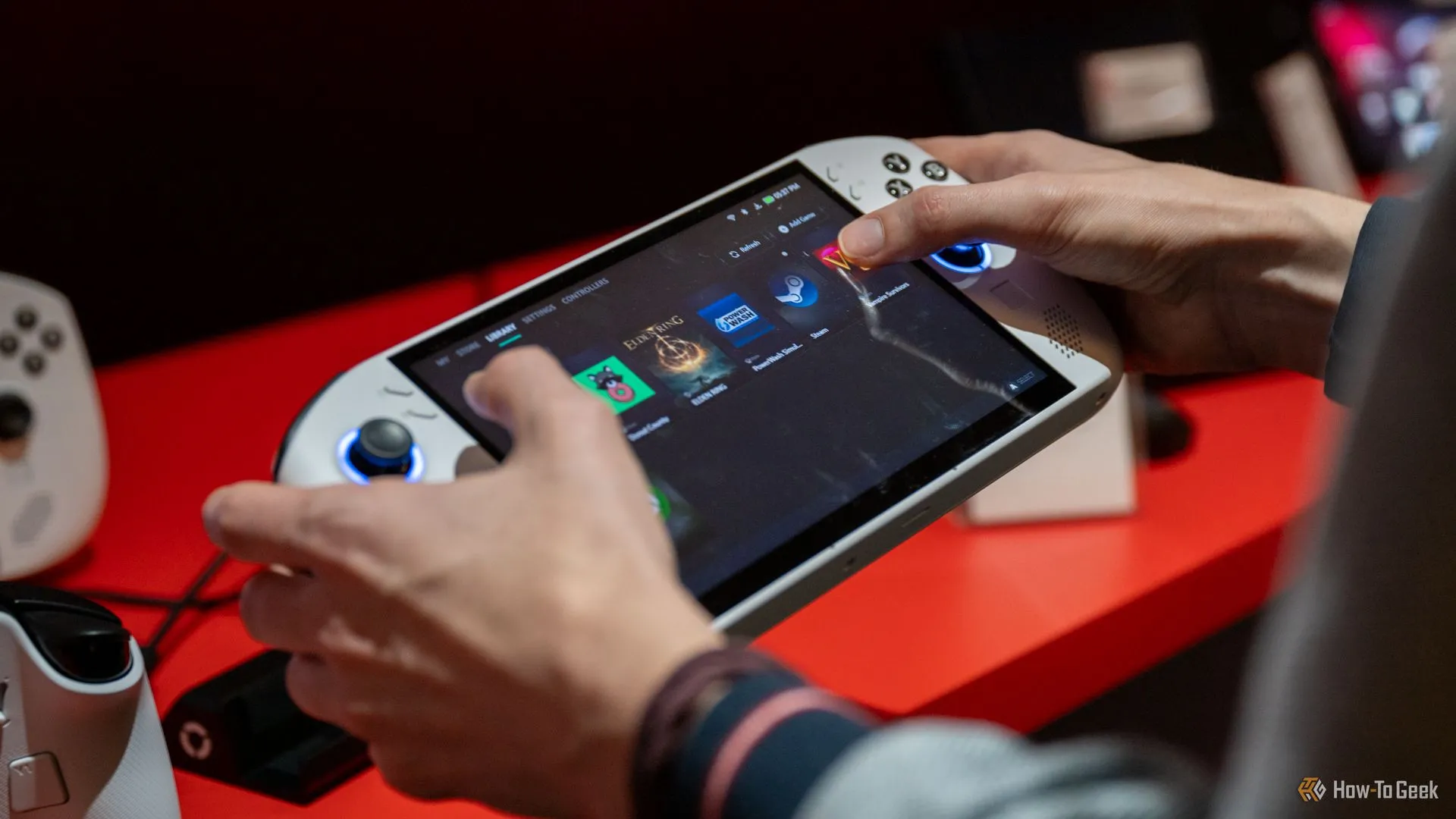 Người dùng thao tác trên màn hình chính của máy chơi game cầm tay Lenovo Legion Go S kích thước lớn, cho thấy khó khăn khi tiếp cận các khu vực trung tâm.