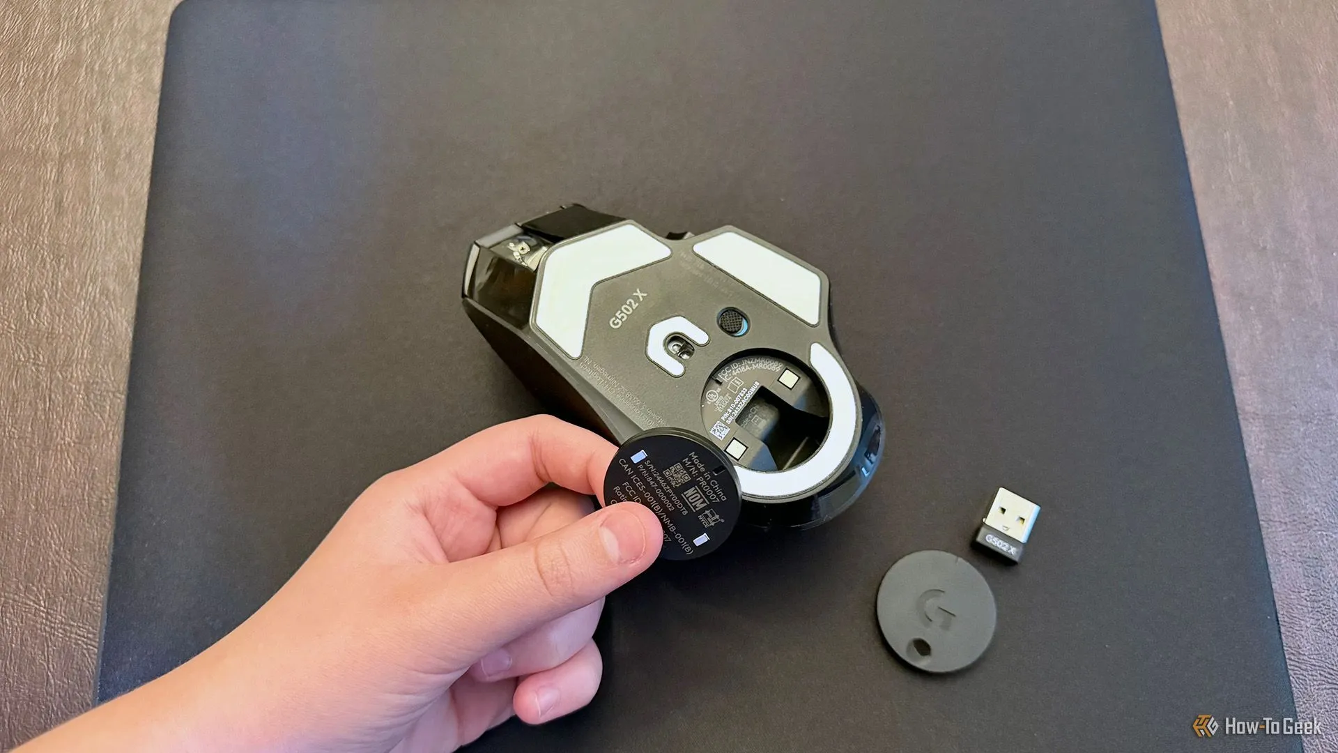 Quá trình lắp đặt Powerplay 2 coin vào khoang chứa pin của chuột chơi game Logitech G502 X Plus Lightspeed.