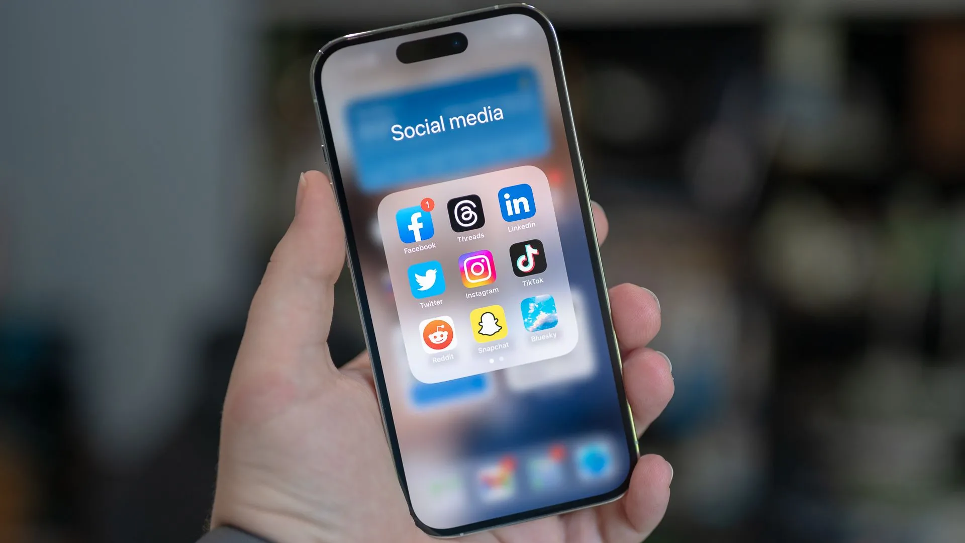 Thư mục mạng xã hội trên iPhone với các biểu tượng ứng dụng phổ biến, tượng trưng cho việc khám phá các diễn đàn trực tuyến thay thế.