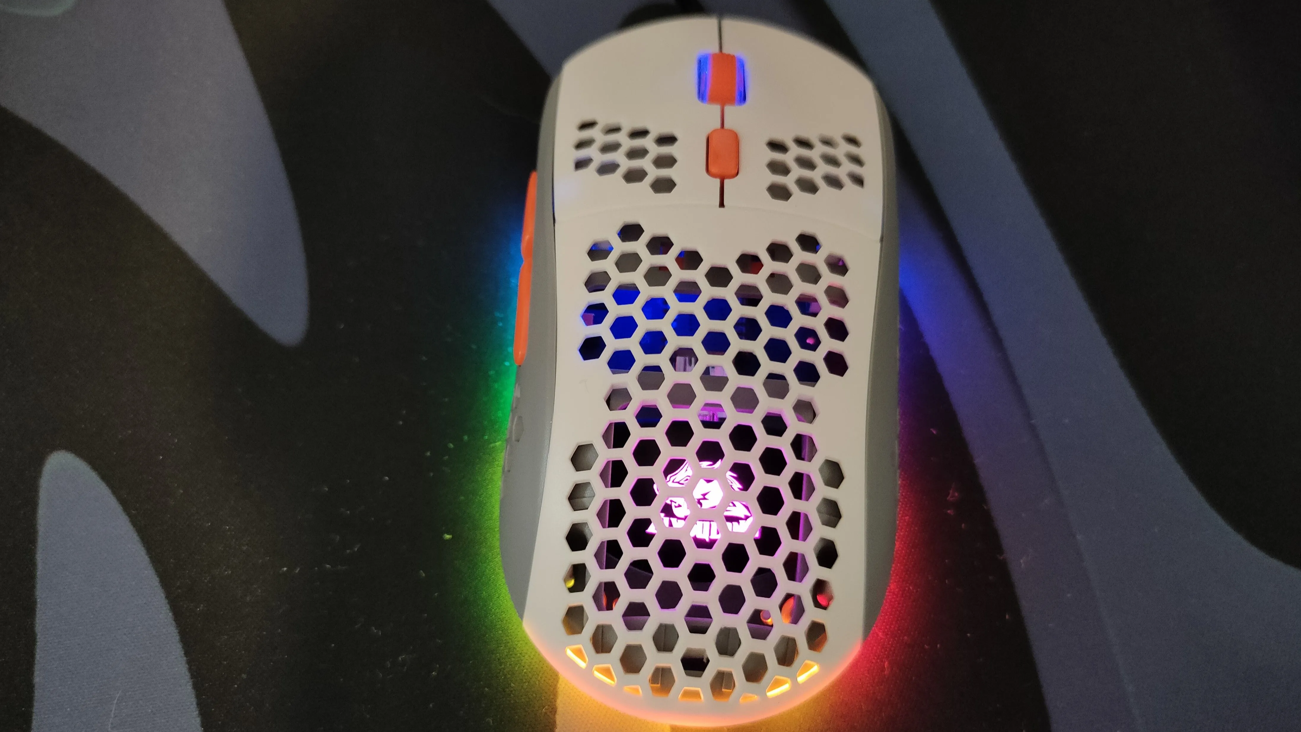 Một chiếc chuột chơi game màu trắng có lỗ và đèn RGB