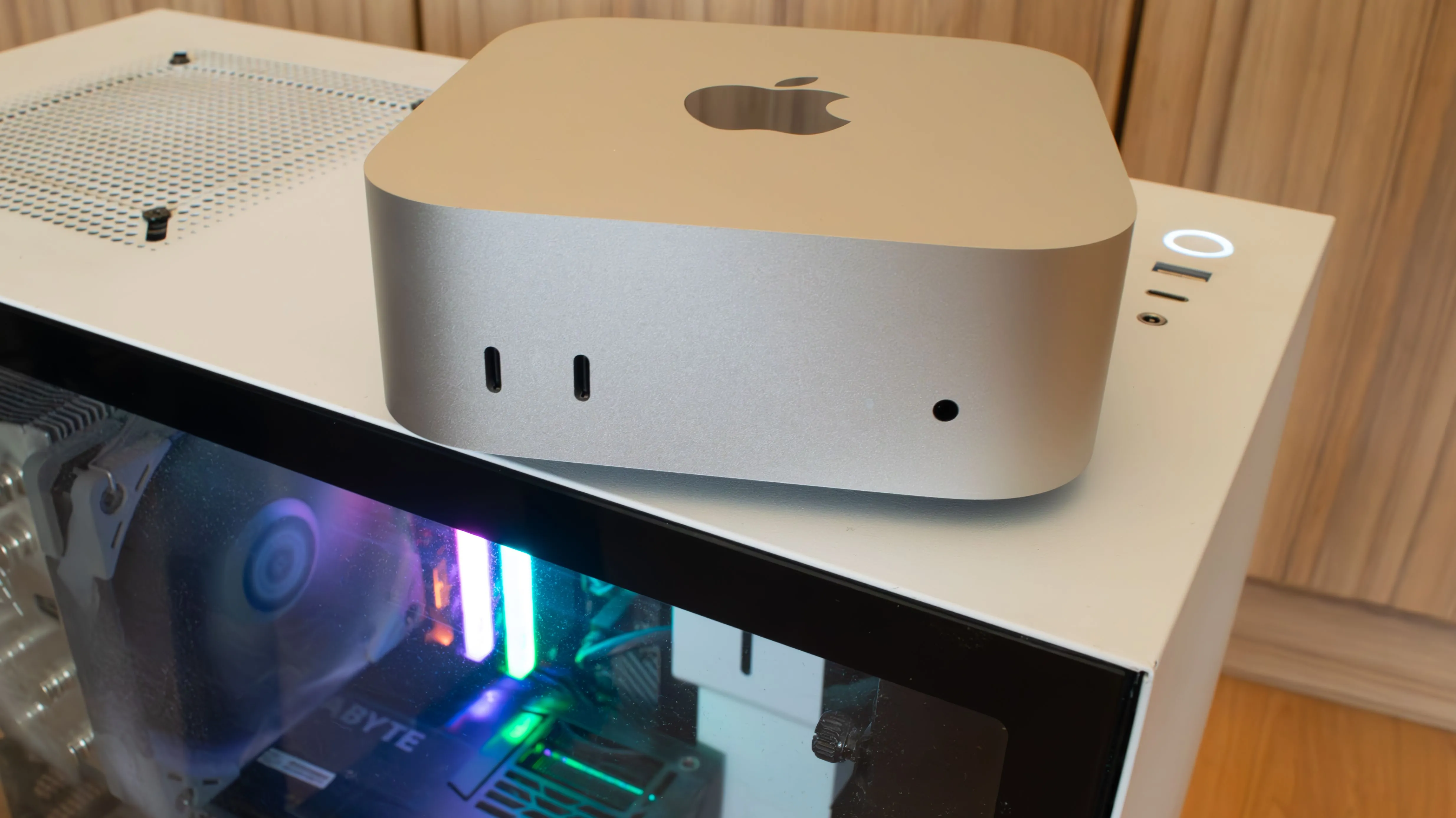 Mac Mini M4 nhỏ gọn đặt trên vỏ PC, minh họa sự khác biệt về kích thước giữa máy tính Mac nhỏ gọn và PC truyền thống.