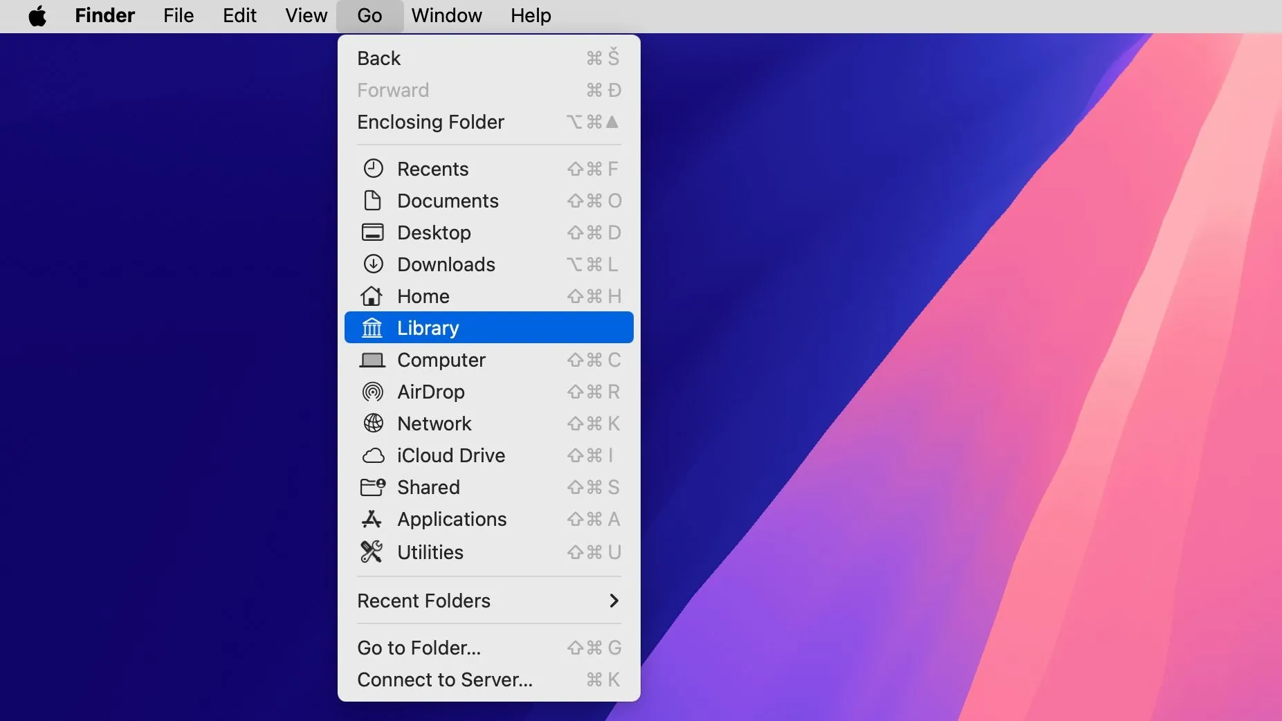 Màn hình desktop macOS với cửa sổ Finder và menu Go, hiển thị tùy chọn &quot;Library&quot; ẩn được chọn để truy cập thư mục hệ thống