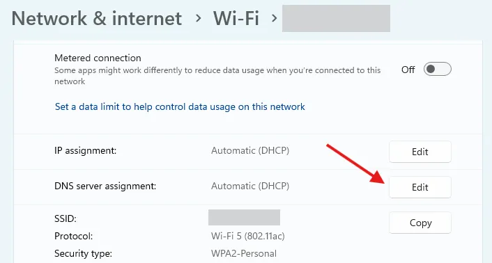 Menu cài đặt Wi-Fi trên Windows 11 với mũi tên đỏ chỉ vào nút &quot;Edit&quot; cho mục &quot;DNS Server Assignment&quot;.